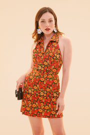 Woman modeling a colorful floral halter mini dress with a fitted waist and playful summer style from Miracle Eye New Arrivals by Miracle Eye